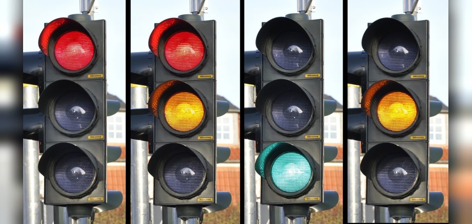 Von links nach rechts werden vier Ampeln mit unterschiedlichen Signalen angezeigt: Rot, Rot-Gelb, Grün, Gelb