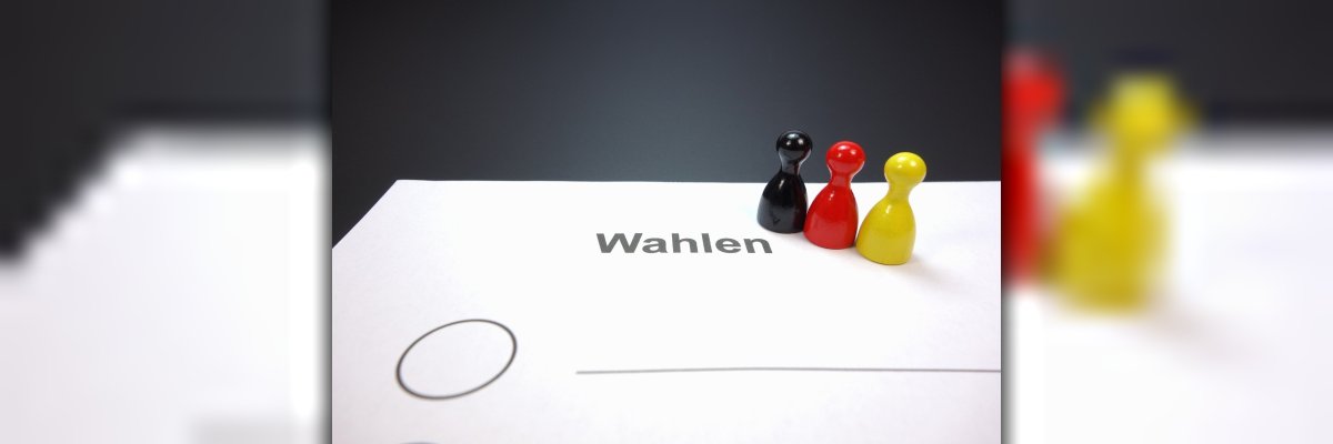 Wahlzettel mit Spielsteinen in schwarz, rot und gold